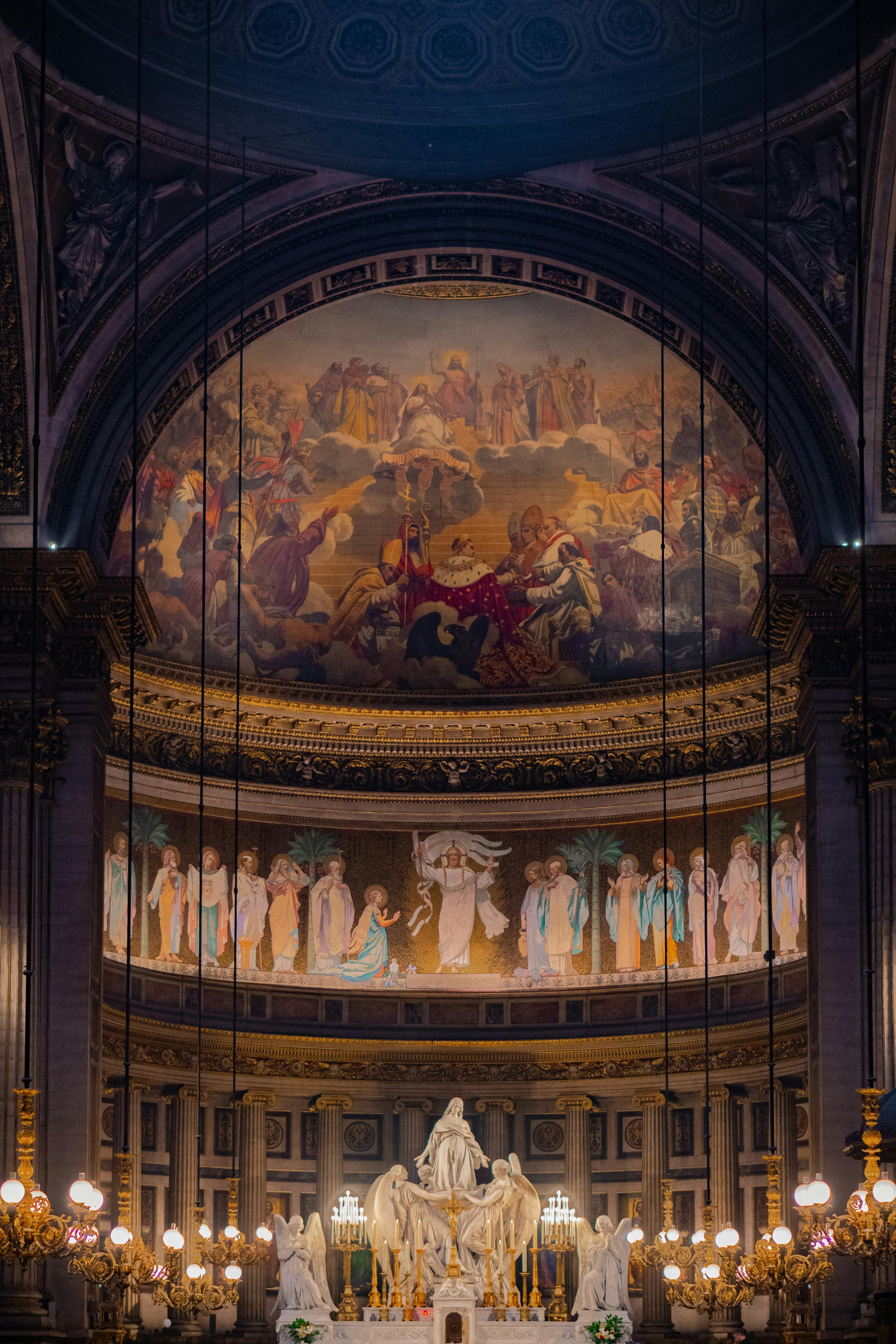 Painted church apse lit by chandeliers